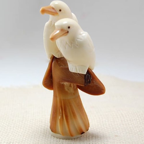 A pair of birds that has been carved with extreme detail in mind. these have been carved out of tagua nuts.