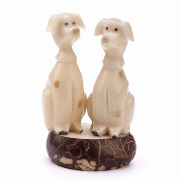 A pair of dalmatians sitting on a platform, made from tagua seeds.
