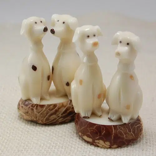 A pair of dalmatians sitting on a platform, made from tagua seeds.