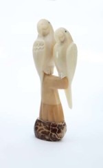 A pair of parrots sitting in a tree, hand carved and made from tagua seeds