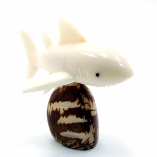 a shork swimming past a rock, this has been hand carved and made from tagua seed.