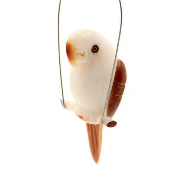 A parrot hanging from a branch, hand carved from tagua nuts.
