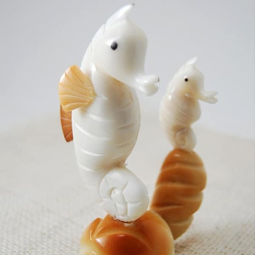 A seahorse sitting with its baby, hand carved and made from tagua seeds.