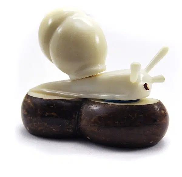 A snail laying on a rock, this was hand carved and made out of tagua seeds