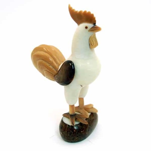 A rooster standing on a rock, hand carved out of tagua nuts