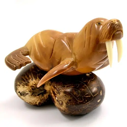 A walrus that is lying down, hand carved and made from tagua seeds.