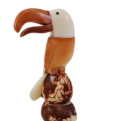 A toucan sitting on a rock, hand carved and made from tagua seeds.