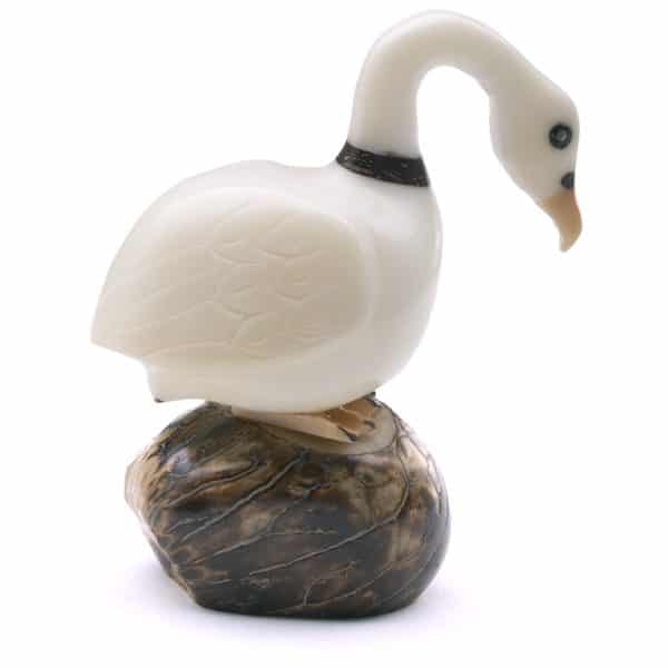 A swan sitting on a rock hand carved and made from tagua seeds