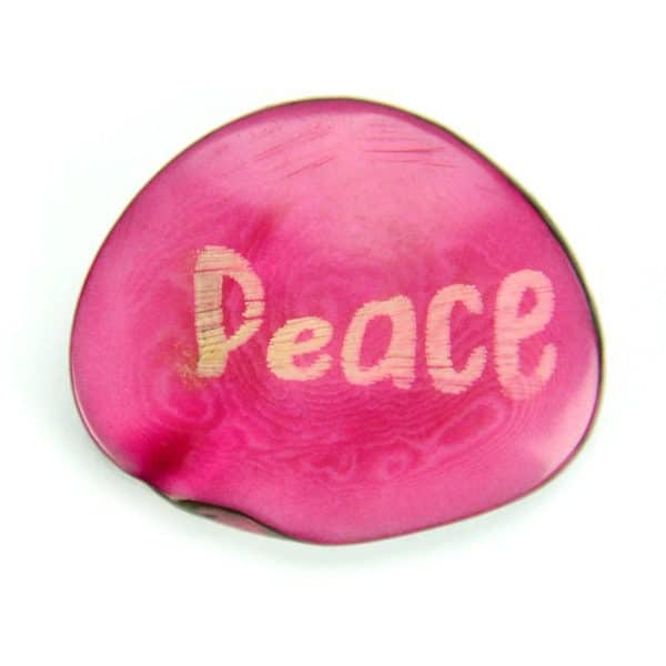 A tagua seed that says peace on it