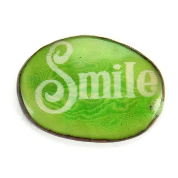 A tagua seed that says smile on it