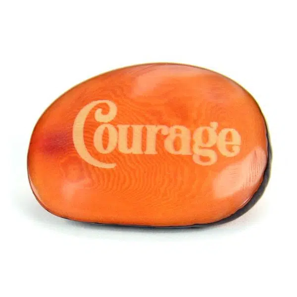A tagua seed that says courage on it