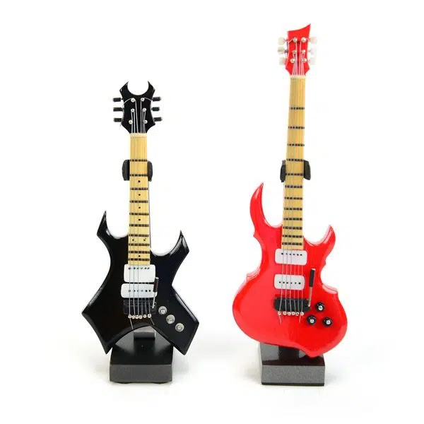 two more different guitars sitting next to each other, this picture has the black one on the left and the red one on the right