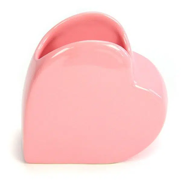 A pink vase shaped like a heart, great for holding things.