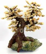 this tree is hand sculpted and sits on top of a slab of serpentine