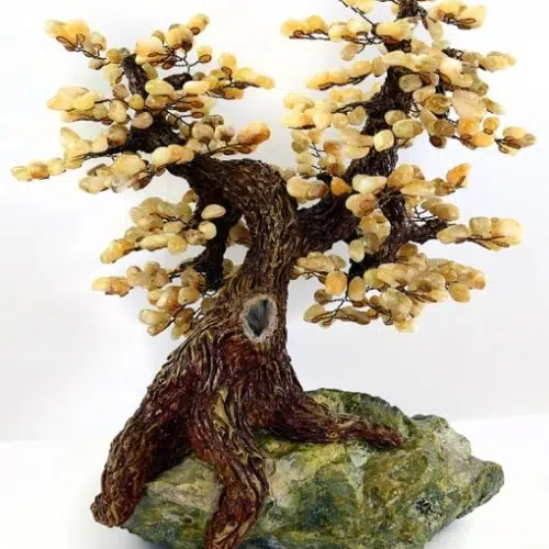this tree is hand sculpted and sits on top of a slab of serpentine