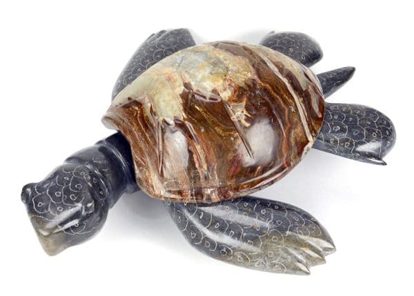 A large marble/onyx turtle, has a dark brown shell with with some dark blue legs and arms