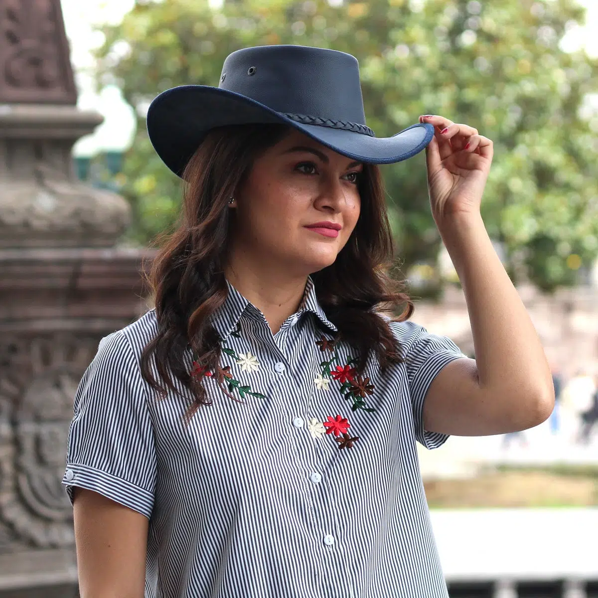 A young lady wearing a leather hat that comes in a variety of colors