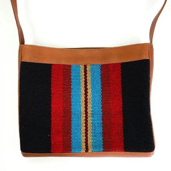 Tan leather crossbody bag with black, red, blue and beige striped pattern