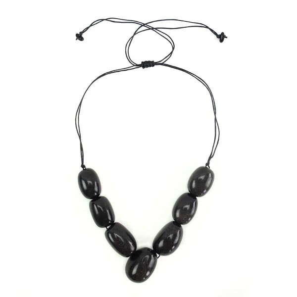 A picture of the siete tagua necklace, comes in a verity of colors. The color in this picture is black.