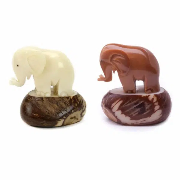 Two elephants made from tagua seeds standing next to each other, they come in different colors, white and brown
