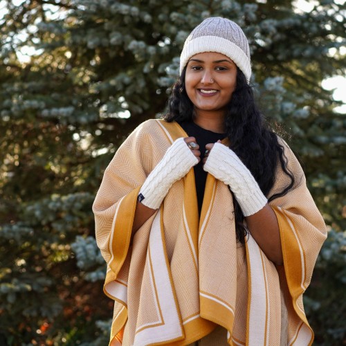 A young women wearing the yellow twill alpaca cape