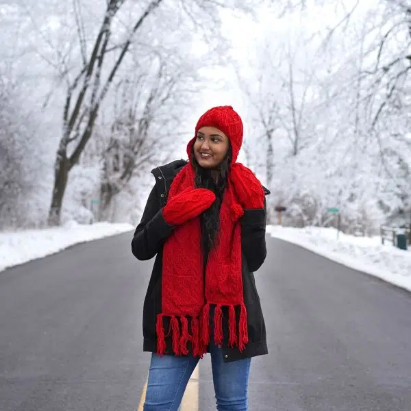 young women wearing the hand knit wool scarf showing the pockets and how bright it looks