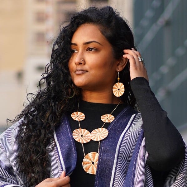 A young women wearing the orange disco straw set.