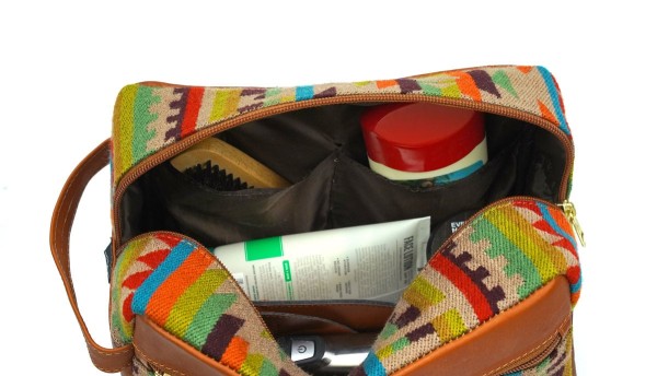 Large tan leather dopp kit bag filled with toiletry items