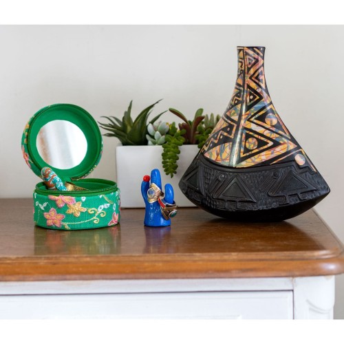 A clay pottery vase sitting on a shelf with a ring holder and a jewelry storage box