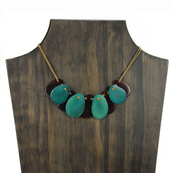 A picture with nine slices of tagua arranged on the necklace, comes in a verity of colors the color in this picture is brown and turquoise.