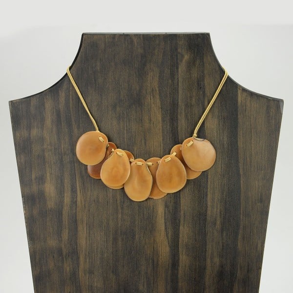 A picture with nine slices of tagua arranged on the necklace, comes in a verity of colors the color in this picture is tan.