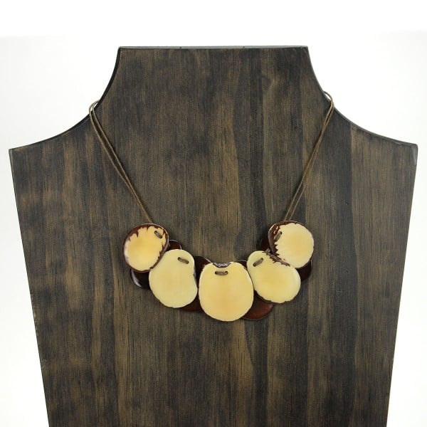 A picture with nine slices of tagua arranged on the necklace, comes in a verity of colors the color in this picture is white.