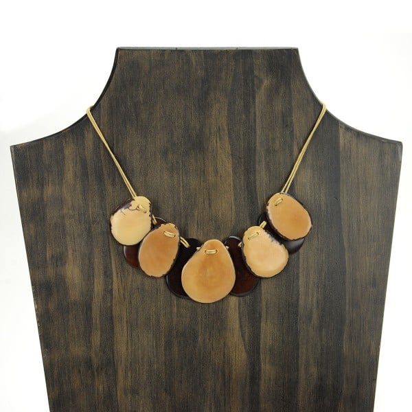 A picture with nine slices of tagua arranged on the necklace, comes in a verity of colors the color in this picture is brown, and white.