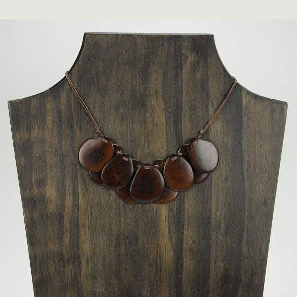 A picture with nine slices of tagua arranged on the necklace, comes in a verity of colors the color in this picture is brown.