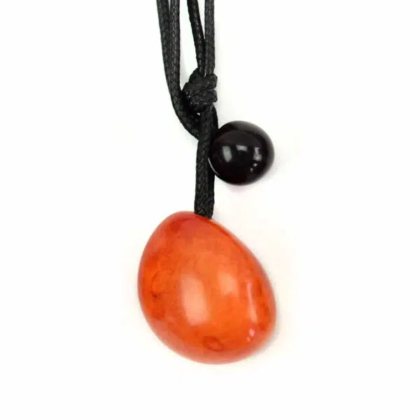 A close up picture of an orange tagua seed necklace.