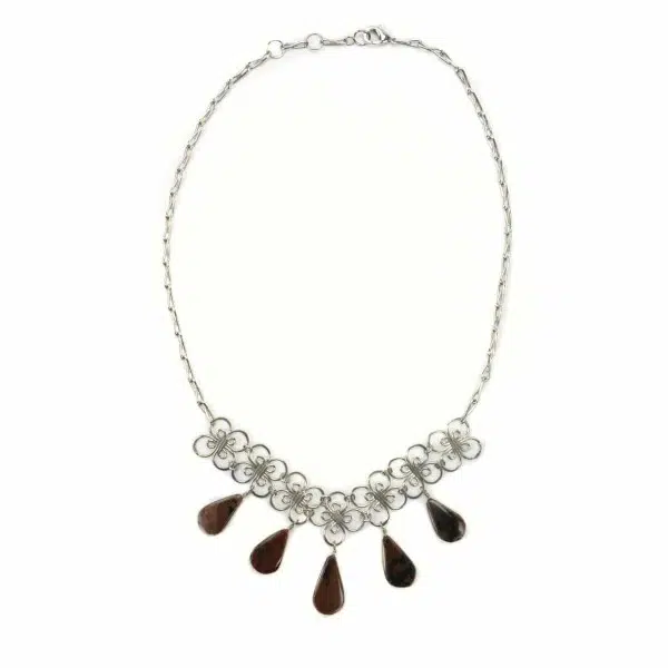 A picture of a teardrop necklace, the gem stones come in dark brown.