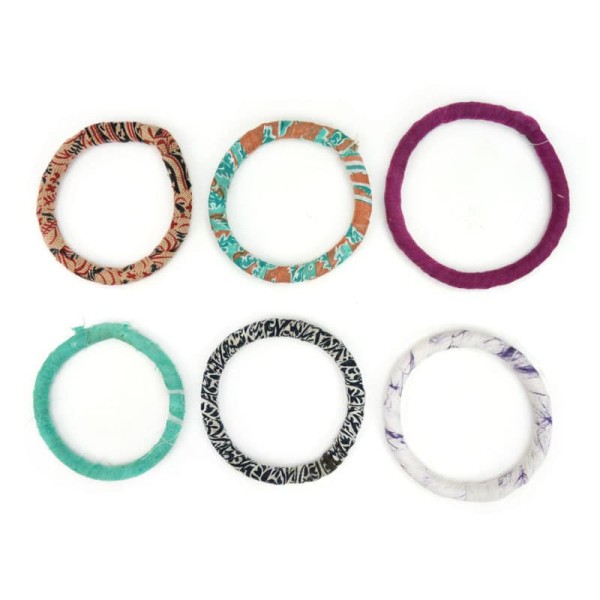 A top down picture of the adult bangle bundles coming in colors of, tan, turquoise, purple, black, and white.