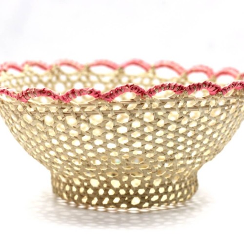 A close up of a bowl that was hand woven straw bowl